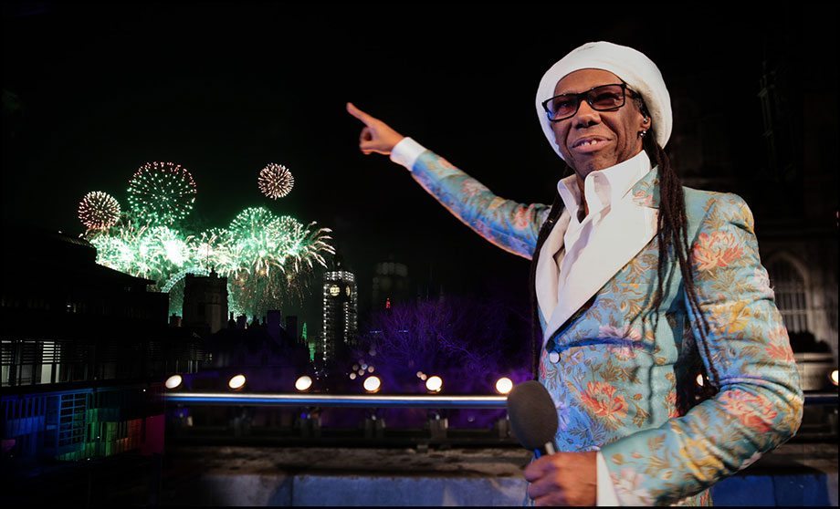 Nile Rodgers with mic on CHW balcony during NYE fireworks