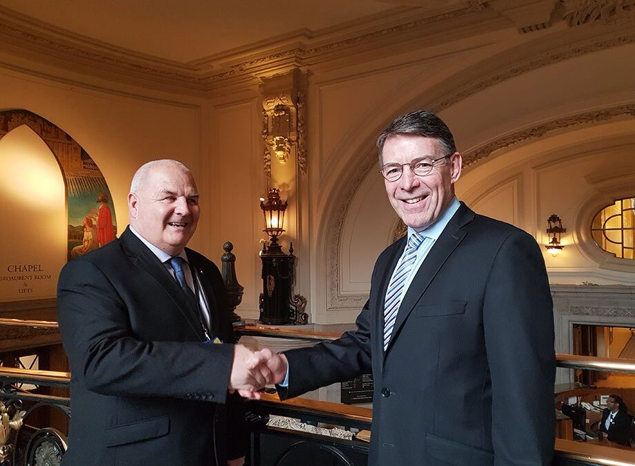 Two men shaking hands inside Central Hall Westminster